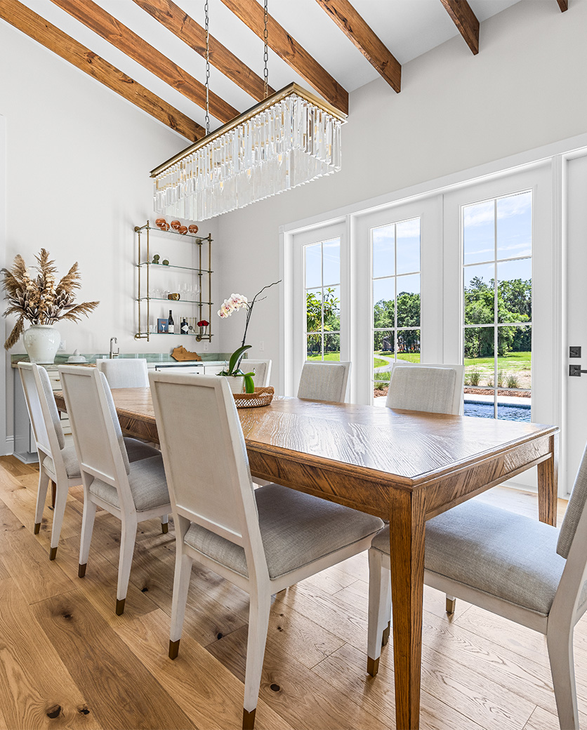 Dining area with a wooden table and large windows in a modern home