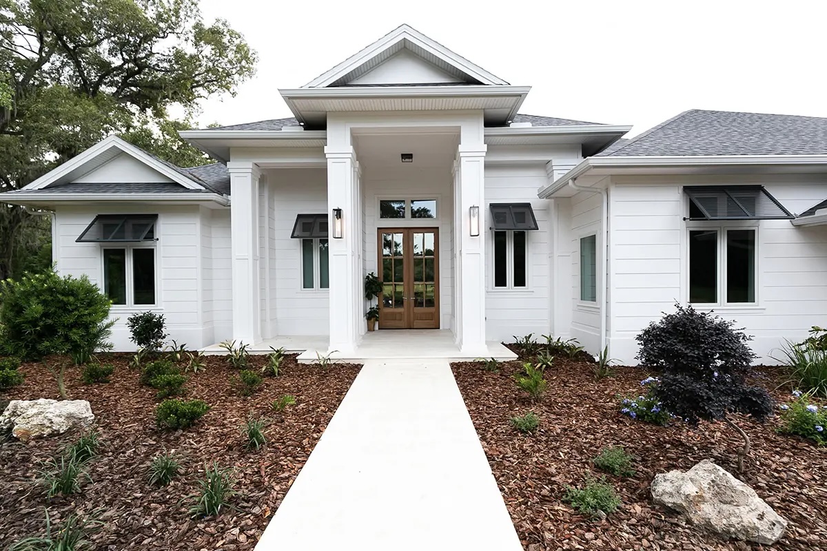 Front view of a modern white home with a landscaped walkway