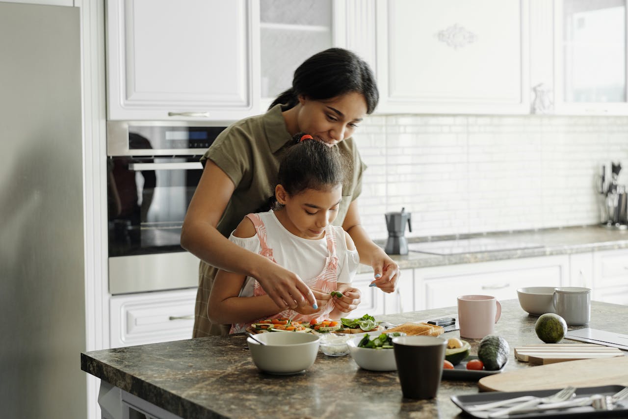 A mother and young child prepare a meal in a modern kitchen