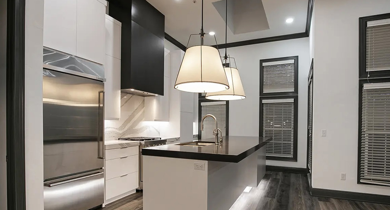 Modern kitchen with an island, pendant lighting, and dark flooring